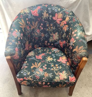 a chair with a floral upholstered seat and wooden legs