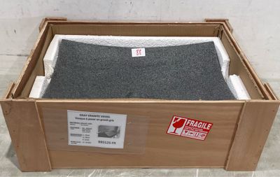 une boîte en carton posée par terre, contenant une couverture