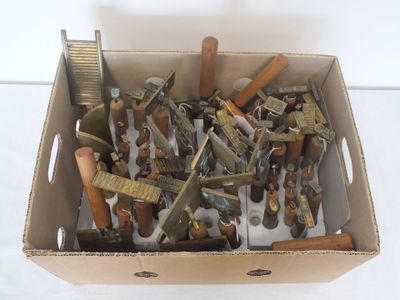 une boîte en carton remplie d'outils divers posée sur une surface blanche