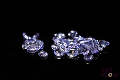 un gros plan sur un bouquet de diamants violets posés sur une surface noire