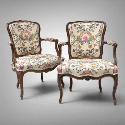 paire de fauteuils de style Louis XV aux accoudoirs rembourrés d'un motif floral
