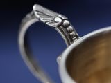 a silver cup that has a handle on it