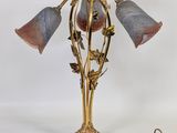 une photo d'une lampe de table sur laquelle sont posées trois fleurs