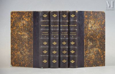 un vieux livre posé sur une table, avec quelques livres posés dessus