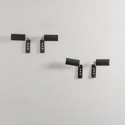 three pieces of black metal hang on a wall next to a white wall