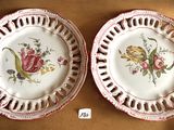 two plates with flowers on them on a table