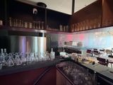 bottles and glasses are lined up on a bar in a restaurant