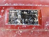 un gros plan d'une plaque métallique sur un véhicule rouge