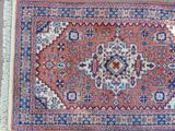 an oriental rug with a blue and red design on a wooden floor
