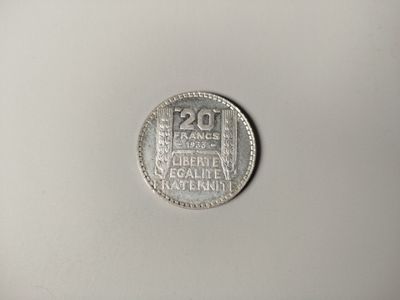 a close up of a silver coin on a white surface