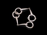 gros plan d'un bracelet en argent sur fond noir