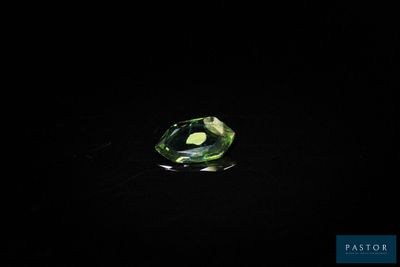 gros plan d'un diamant vert sur une surface noire