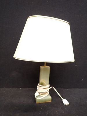 une lampe verte avec un abat-jour blanc posée sur une surface noire