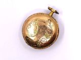 a gold colored pocket watch with a chain on it
