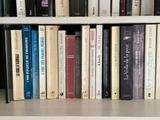 many books that are on a shelf in a library