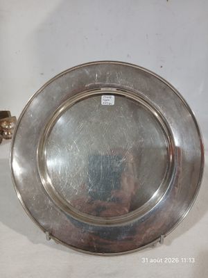 un plateau en argent posé sur une table, sur lequel se trouve une bougie