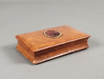 an image of a small wooden box with a coin on top of it