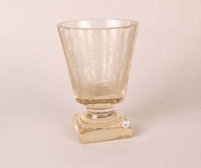 a glass vase with a gold base on a white background