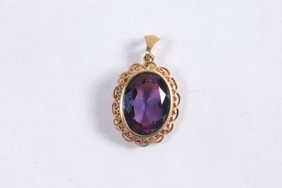 un gros plan d'un pendentif en pierre violette posé sur une surface blanche