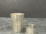 two silver cups sitting on top of a table next to each other