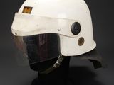 a close up of a helmet on a stand on a black background