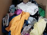 a cardboard box full of clothes that is sitting on the floor