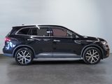 the black suv is parked in a large room with a white wall