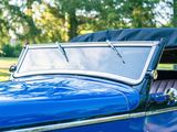 a blue car with a black top parked in the grass