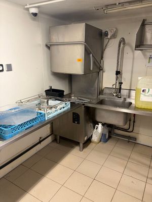 une cuisine avec un évier et un plan de travail sur lequel sont posés de nombreux plats