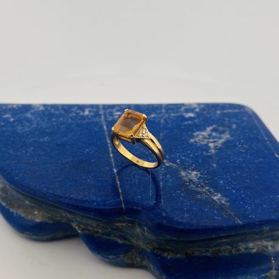 an image of a gold ring with a yellow stone on top of a blue stone