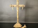 une croix ouvragée posée sur une table, à côté d'une paire de ciseaux