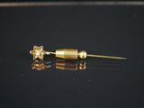 un gros plan sur une paire de boucles d'oreilles en or posées sur une surface noire