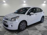 la petite voiture blanche est garée sur un carrelage à carreaux