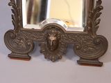 a silver mirror with a lion head on it