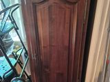 a tall wooden cabinet with a clock on top of it