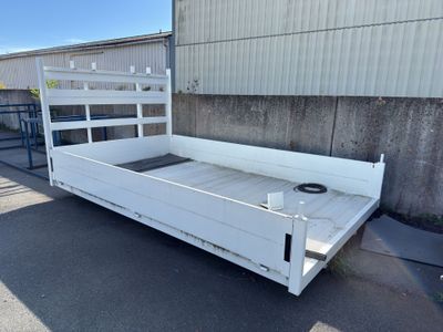 un lit blanc qui se trouve au milieu d'un parking