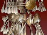 a lot of silver spoons and spoon spoons on the table