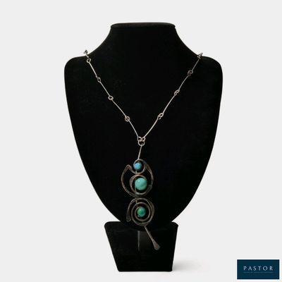 collier avec une pierre turquoise et une chaîne en argent sur un mannequin noir