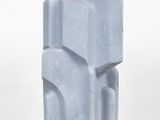 a gray sculpture on a white pedestal on a white surface