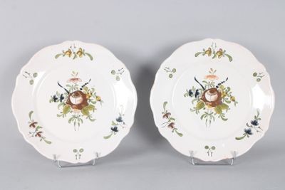two plates with flowers and birds painted on them on a gray surface