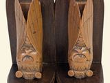 two wooden bookends with carvings of a man and a woman on them