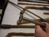 a person holding a hammer in front of a bunch of old tools