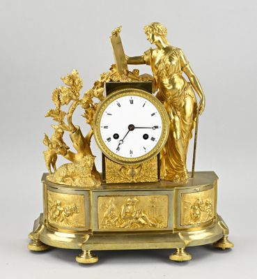 a gold clock with a statue on top of it