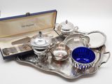 un plateau en argent sur lequel se trouvent des couverts et une tasse bleue