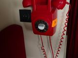 a red telephone on the wall next to a red couch