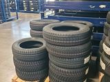 several tires stacked on pallets in a warehouse with pallets in the background