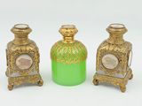trois vases verts et dorés ornés de motifs, posés sur un fond blanc