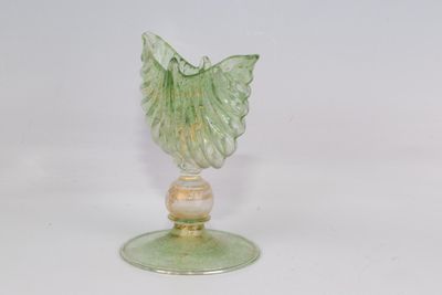 une figurine en verre surmontée d'une feuille verte