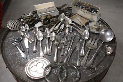 a lot of silver spoons and utensils on a table