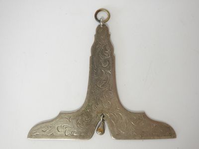 an antique silver plated shoe shaped object on a white surface